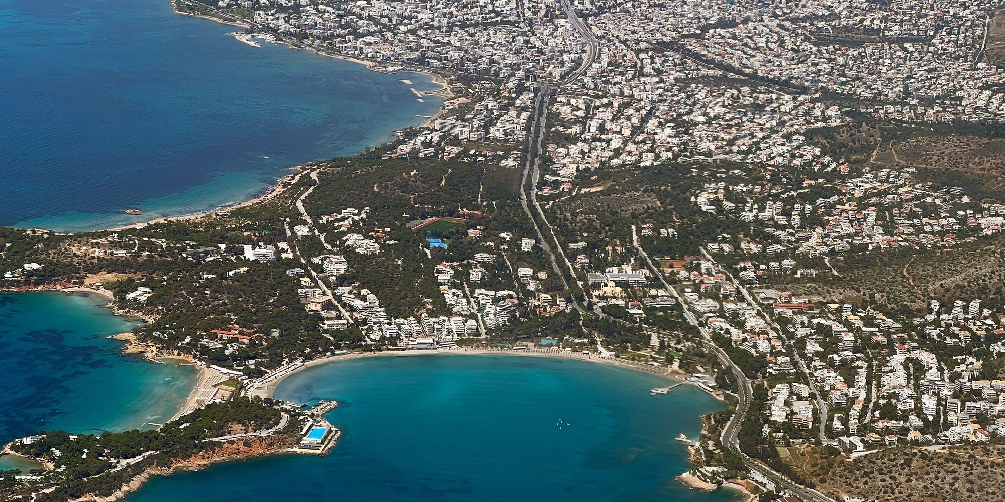 Aerial view of the Athens Riviera at Vouliagmeni, the coast curving north through Voula towards Glyfada